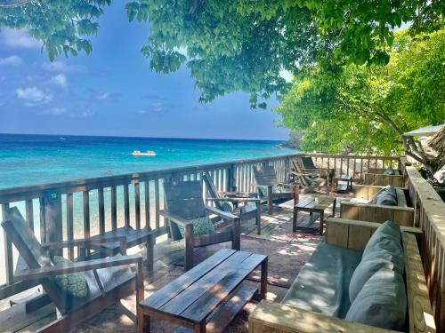 a view of the ocean from a deck with benches at Marazul Dive Resort-Panoramic Ocean View Town Home in Westpunt