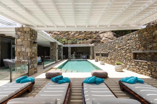 a swimming pool with chaise lounges and a swimming pool at Nammos Hotel Mykonos in Psarou