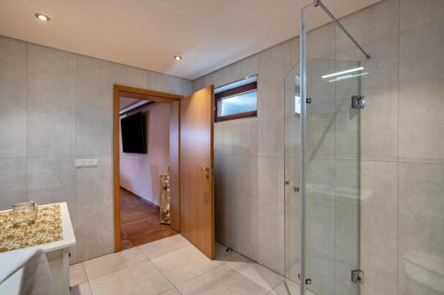 Un baño con ducha y puerta de cristal. en Haus am Bächel 2, en Obersasbach