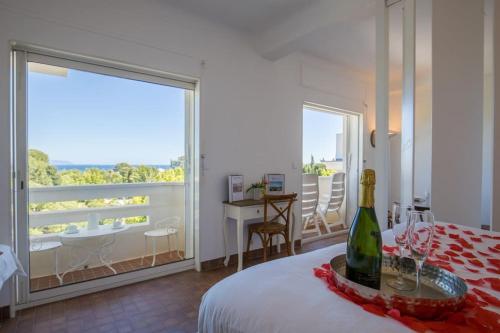- une chambre avec une bouteille de vin sur un lit dans l'établissement Charmant studio avec vue mer à La Ciotat, à La Ciotat