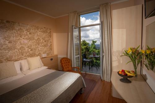 1 dormitorio con 1 cama y ventana con balcón en Hotel Vista Lago, en Brunate