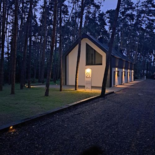 a building with a sign in the middle of a forest at Karłowy Las in Milicz