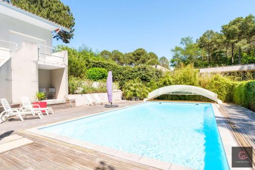 une piscine dans l'arrière-cour d'une maison dans l'établissement Villa avec piscine pour 9 personnes au golf de Biscarrosse, à Biscarrosse
