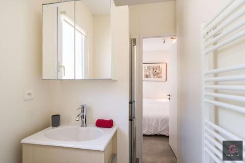 une salle de bain avec un lavabo et un miroir dans l'établissement Villa avec piscine pour 9 personnes au golf de Biscarrosse, à Biscarrosse