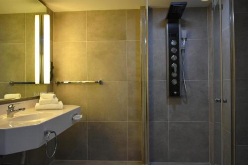 a bathroom with a shower and a sink at TIBET HOTEL am Airport Düsseldorf-Ratingen in Ratingen
