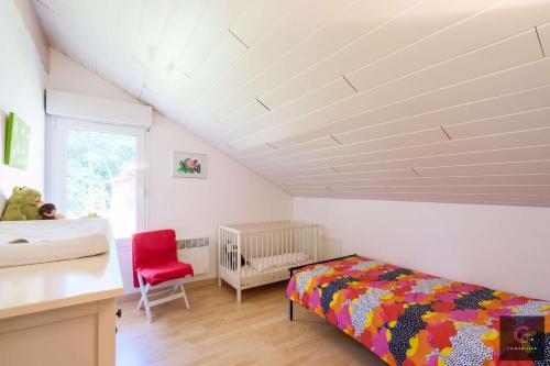 une chambre avec un lit et une chaise rouge dans l'établissement Villa avec piscine pour 9 personnes au golf de Biscarrosse, à Biscarrosse