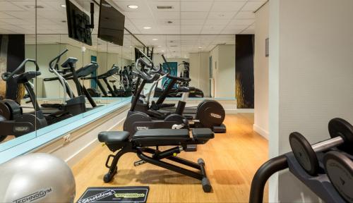 a gym with several treadmills and elliptical machines at Fletcher Hotel-Restaurant Sparrenhorst-Veluwe in Nunspeet