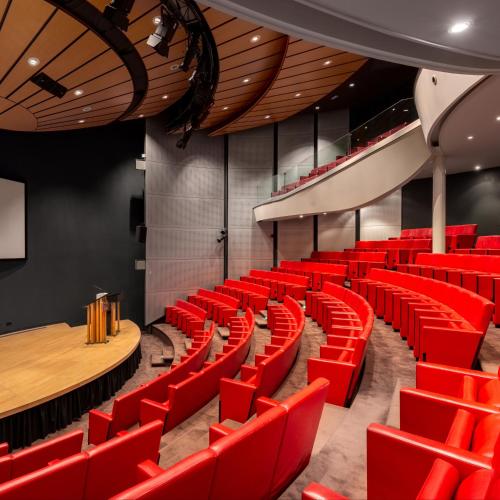 an empty auditorium with red chairs and a stage at Fletcher Hotel-Restaurant Sparrenhorst-Veluwe in Nunspeet