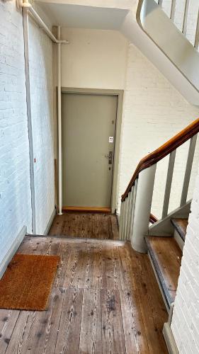 an empty hallway with a door and a wooden floor at Løvstræde apartments from 1 to 6 in Copenhagen