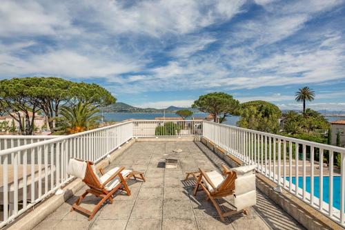 un balcon avec deux chaises et une piscine dans l'établissement Appartement Signac - Welkeys, à Saint-Tropez
