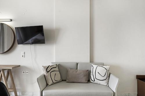 a living room with a couch and a tv at Sunset Premium Studio D in Agios Nikitas