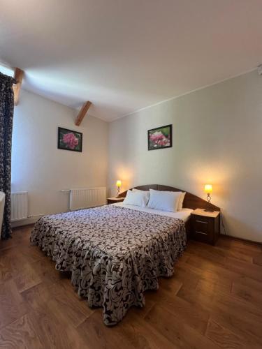 1 dormitorio con 1 cama grande y 2 lámparas en Apart hotel Asotel, en Járkov