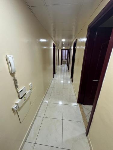 a hallway with a phone on the wall and a hallwayngthngthngthngthngth at Elegant Master Suite with Luxurious Compfort in Ajman 