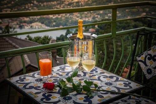 una mesa con 3 copas de vino en el balcón en Hotel Vista Lago, en Brunate