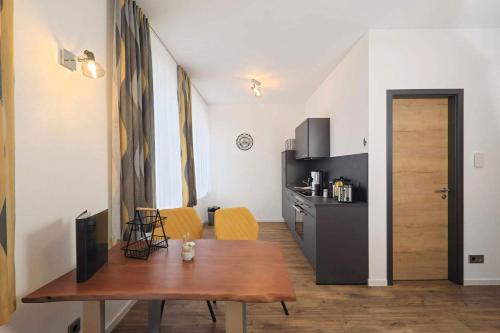 a living room with a wooden table and a kitchen at Ferienquartier Forsthaus 2 in Bad Gottleuba