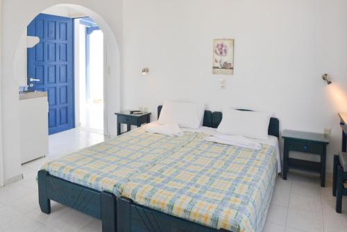 1 dormitorio con 1 cama y puerta azul en Plaza Studios, en Agia Anna de Naxos