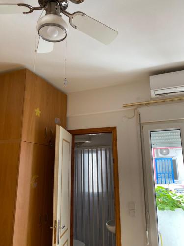 a ceiling fan in a room with a door at Igoumenitsa heart flats to let Mariasroom studios appart seaside-city Spyropoulos in Igoumenitsa