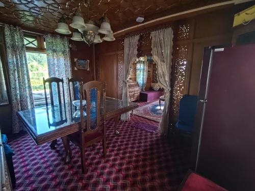 a dining room with a table and chairs in a room at Houseboat New Shamus Maqbool in Srinagar