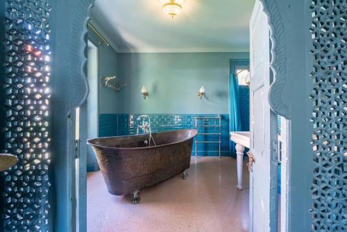 La salle de bains est pourvue d'une grande baignoire et de murs bleus. dans l'établissement Villa luxueuse à Cannes + piscine, à Cannes