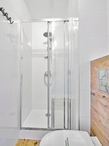 a bathroom with a shower and a white toilet at Oaza Leba - Idealny dla rodzin z dziecmi - FIRST MINUTE SEZON 2026!!! in Łeba