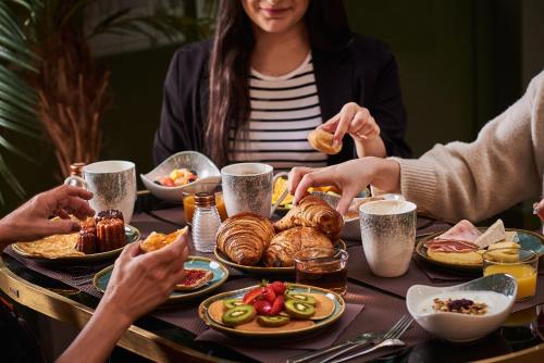 a group of people sitting around a table eating food at Hotel Konti Bordeaux by HappyCulture in Bordeaux