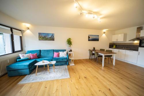 a living room with a blue couch and a table at Höri-Nest Wohlfühl-Appartement in Gaienhofen