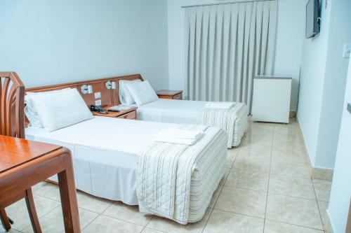 a hotel room with two beds and a table at Italian Palace Hotel in Sinop