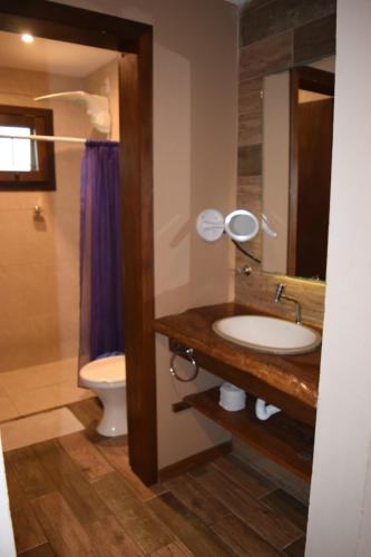 a bathroom with a sink and a toilet at Vila Tamú in Praia do Rosa