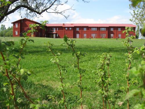 a red building in the middle of a field at Sahlströmsgården in Torsby