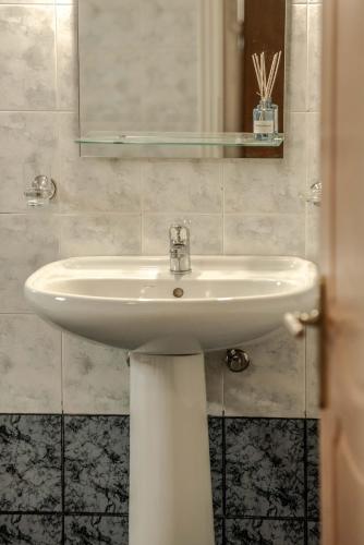 a bathroom with a white sink and a mirror at Nitsa's Corner in Zakynthos Town
