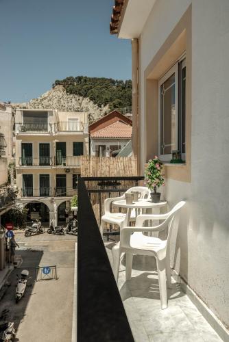 a row of white chairs on the balcony of a building at Nitsa's Corner in Zakynthos Town