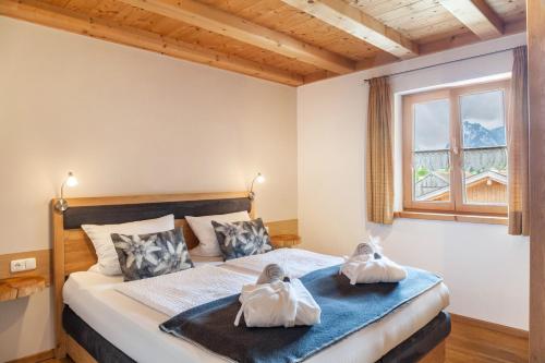 翁特拉梅爾高的住宿－Wohnung Grün - Ferienhaus Ammergau，一间卧室配有一张床,上面有两条毛巾