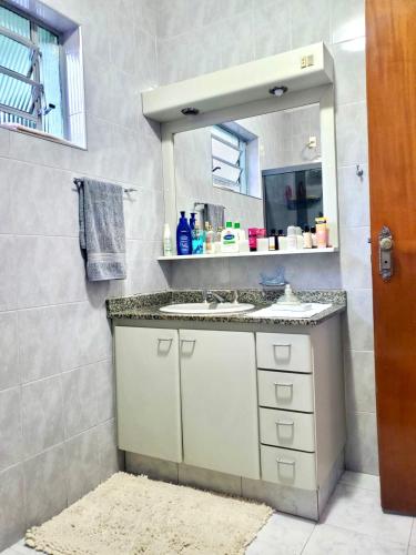 a bathroom with a sink and a mirror at Rios Home in Poços de Caldas