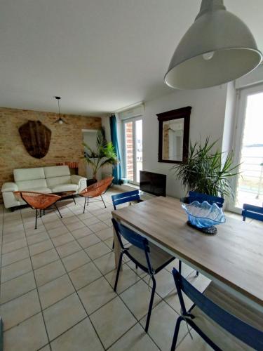 キブロンにあるappartement vue merのリビングルーム(木製テーブル、椅子付)