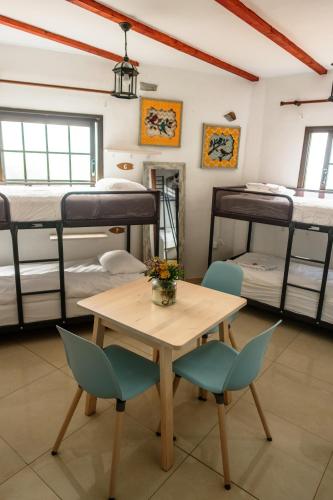 a room with a table and chairs and bunk beds at Casanaga in Almáciga