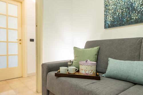 a tray on a couch with two mugs on it at Varese Centro - ViVa Apartment - Free WiFi in Varese