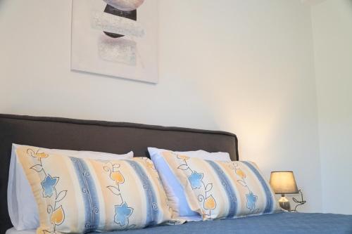 a bed with blue and white pillows on it at Anna's Apartments in Kremasti