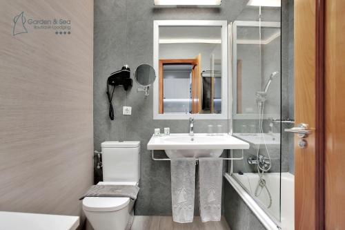 a bathroom with a sink and a toilet and a mirror at Apartamentos Garden & Sea Boutique Lodging by LIVVO in Morro del Jable