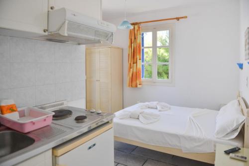 a small kitchen with a bed and a sink at Plaza Studios in Agia Anna Naxos