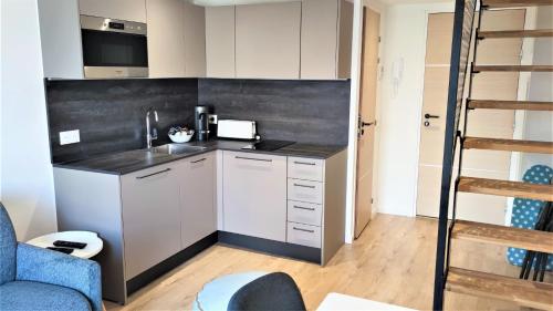 une cuisine avec des armoires blanches et un comptoir noir dans l'établissement Lamartine hypercentre 511, à Nice