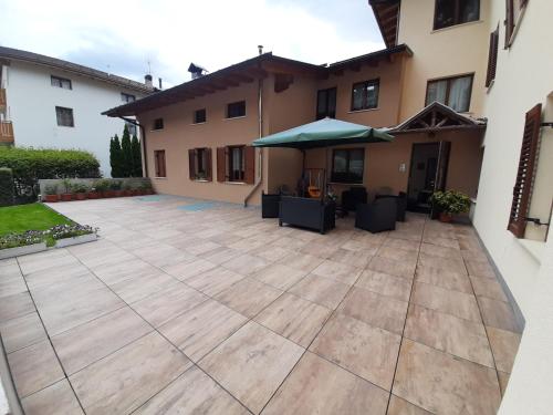 a patio in front of a house with an umbrella at Casa Viola in Cavedago