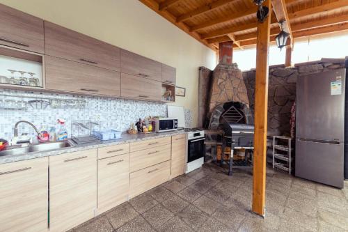 a kitchen with wooden cabinets and a stone oven at Casa Del Mare in Chernomorets