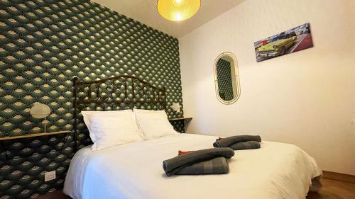 um quarto com uma cama com duas toalhas em Voyage à Little Havana em Bouguenais