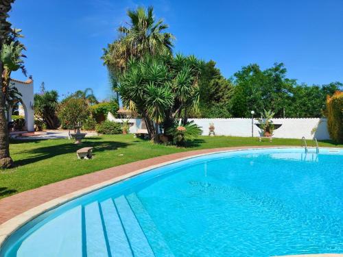 uma grande piscina num quintal com palmeiras em Villa Alfonsa, Fontane Bianche, Siracusa, PRIVATE POOL, 10min from the beach em Fontane Bianche