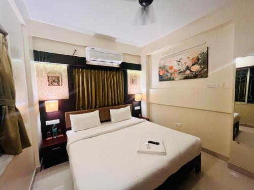 a bedroom with a large white bed in a room at Chopson's Parc in Thākurdwari