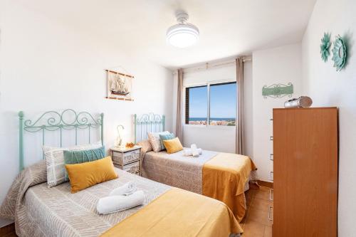 拉安蒂拉的住宿－Bonito Piso a 1 minuto de la Playa，一间卧室设有两张床和窗户。