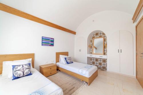 a bedroom with two beds and a mirror at Villa AZUL in Mezraya