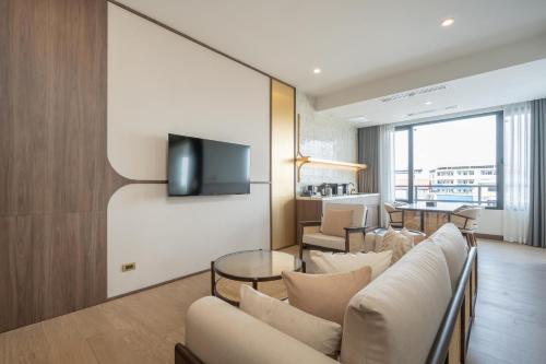 a living room with a couch and a tv at Pranakorn Heritage Hotel in Bangkok
