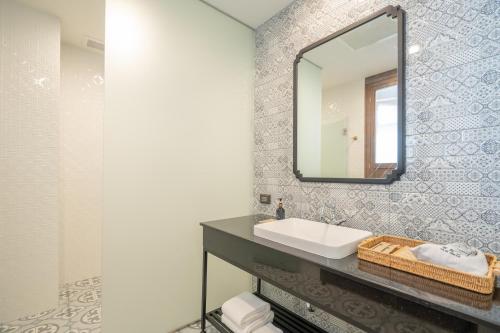 a bathroom with a sink and a mirror at Pranakorn Heritage Hotel in Bangkok