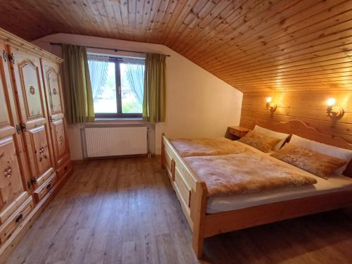 Un dormitorio con una cama grande en un ático. en Gästehaus Kayetan, en Klais